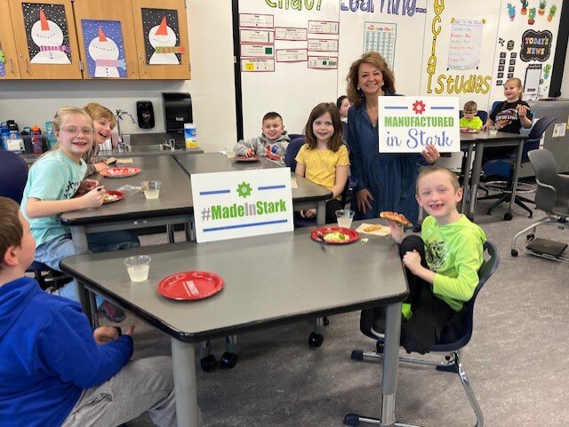 Second grade students show their manufacturing coloring contest artwork